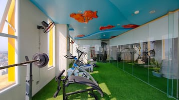 Ein Fitnessraum mit Trainingsgeräten, Kunstgrasanlage und einer Decke mit Fischmotiven.