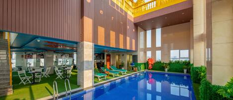 A swimming pool with lounge chairs and a bar area.