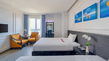 Quarto de hotel com duas camas, televisão, secretária e uma cadeira, e obras de arte na parede.