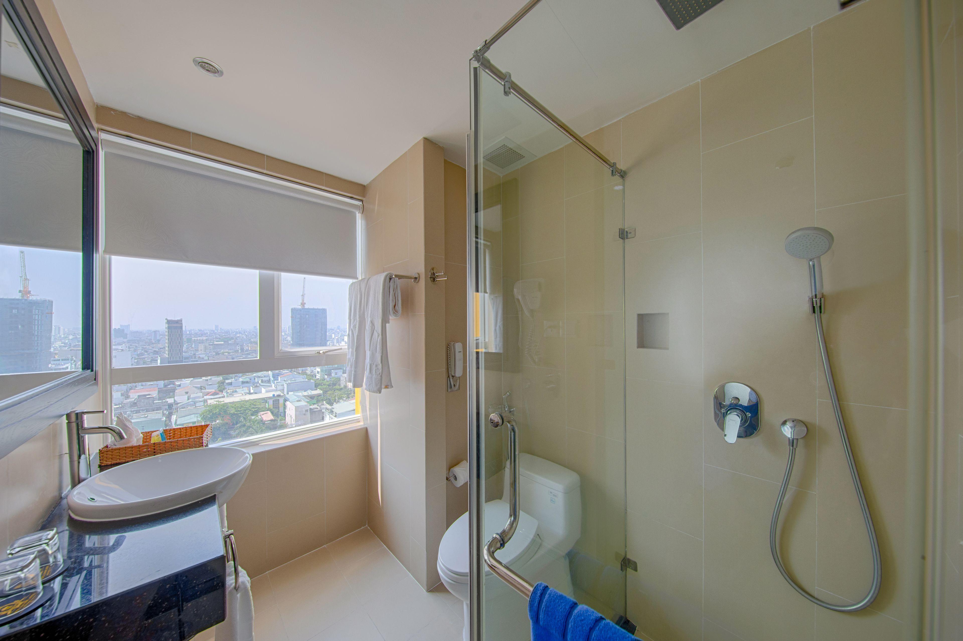 A modern bathroom with a glass-enclosed shower, a toilet, and a sink.