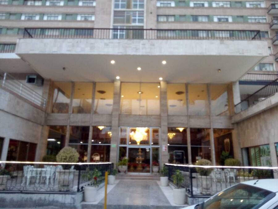 Vestíbulo de un hotel moderno de varios pisos, con un atrio central y amplias ventanas.