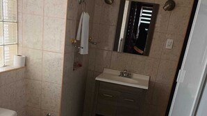 Un baño pequeño con inodoro, lavamanos y espejo.