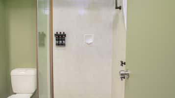 Une salle de bain avec une douche à parois de verre, des toilettes et un lavabo.