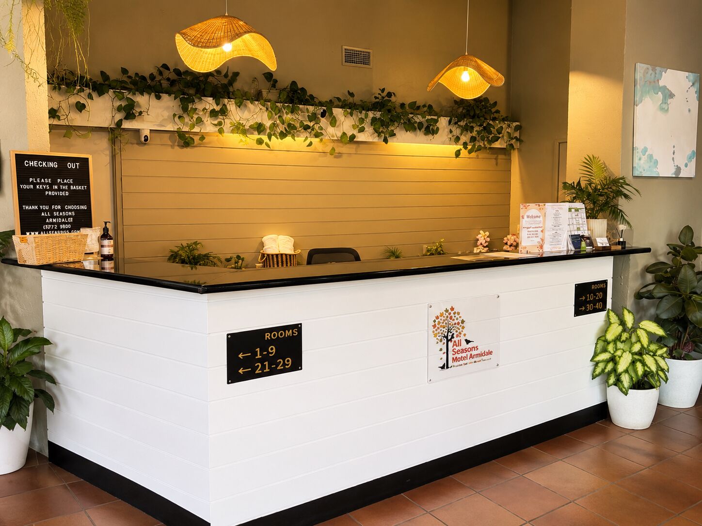 Un mostrador de recepción de hotel con un cartel que indica los números de habitación del 1 al 9 y del 21 al 29.