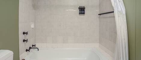 A bathroom with a bathtub, a shower, and a toilet.