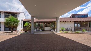 A modern building with a covered entrance, potted plants, and a gravel driveway. - All Seasons Motel Armidale (Armidale)