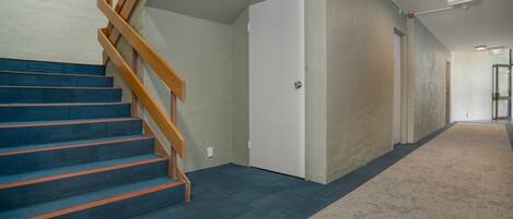 Una escalera con barandillas de madera que conduce a una puerta blanca.