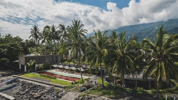 Un resort con piscina, mobiliario exterior y palmeras.