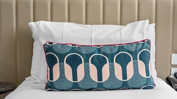 A bed with a beige headboard and a white pillow.