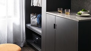 A modern kitchenette with a built-in oven, a countertop with a sink, and a wine rack. - Veriu Green Square (Alexandria)