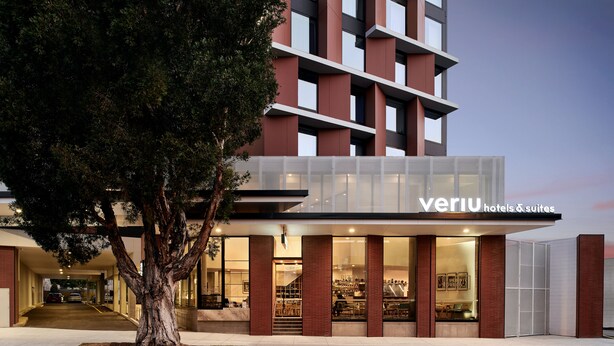 A modern hotel with a glass facade, a visible entrance, and a tree in front. - Veriu Green Square (Alexandria)