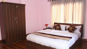 A bedroom with a wooden bed, a nightstand, a wardrobe, and a window with curtains. - Sitapaila Homestay and Apartment (Nagarjun)