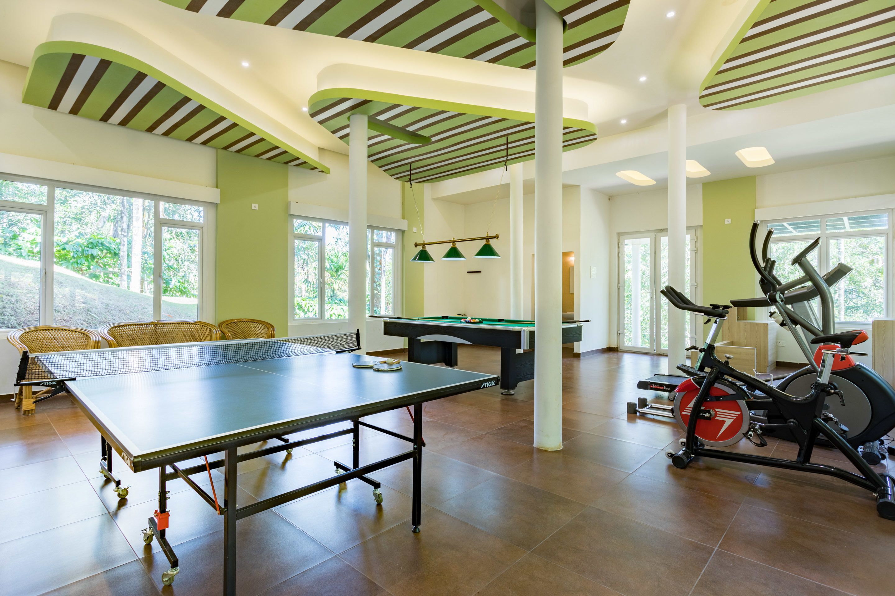 Amplio espacio interior con mesa de ping pong, bicicletas estáticas y mesa de billar.