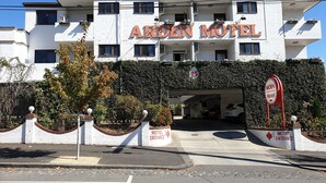 The exterior of the Arden Motel, featuring a white facade, a covered parking area, and a sign indicating the motel entrance. - Arden Motel (North Melbourne)
