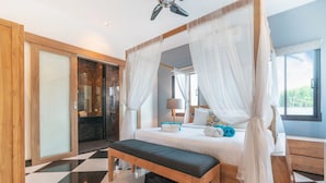 Ein Schlafzimmer mit einem Himmelbett, einer Bank, einem Nachttisch und einem großen Fenster.