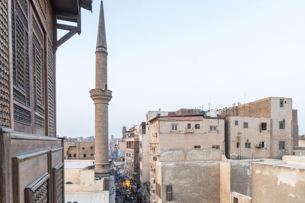 Kapea katu, jonka molemmin puolin kohoavat historialliset rakennukset, ja kauempana näkyy huomiota herättävä minareetti.
