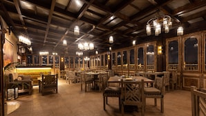 A restaurant with wooden furniture, chandeliers, and large windows. - Le Riad Hotel de Charme (Cairo)