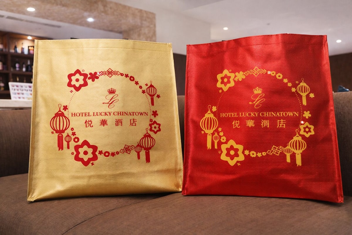 Two bags with text and decorative elements, placed on a couch.