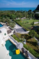 Vista aérea de un complejo turístico con piscina, zona de descanso y jardines ajardinados.