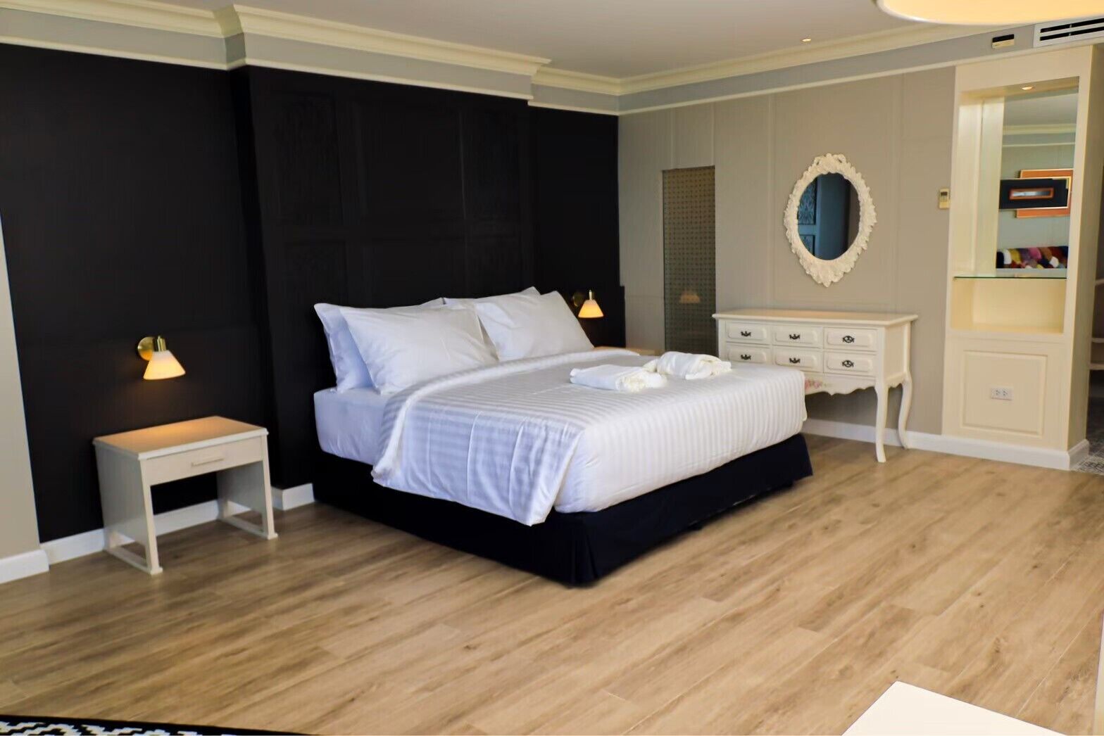 Une chambre à coucher avec un lit, des tables de chevet, une commode et un miroir.