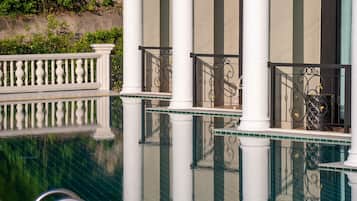 Un área de piscina con columnas y barandilla blancos.
