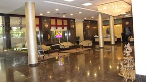 A spacious lobby with a polished marble floor, a reception desk, and a decorative chandelier. - Brilliant Hotel & Convention Center (Indore)