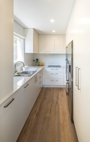 Enjoy cooking in this well-equipped kitchen with an oven, stainless steel sink, and ample countertop space.