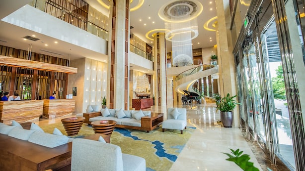 A spacious lobby with a reception desk, seating areas, a staircase, and large windows. - Central Luxury Ha Long Hotel (Bai Chay)