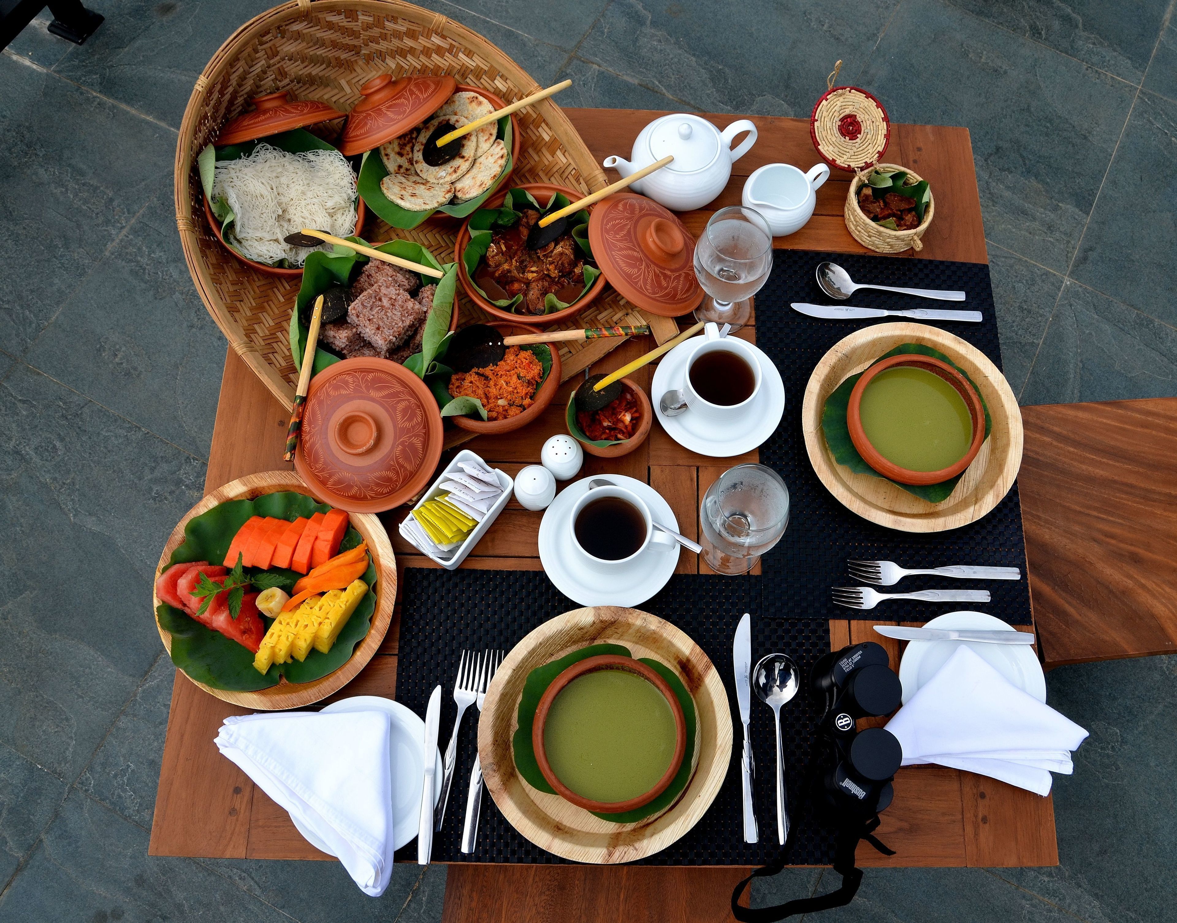 A table set with various dishes, including a bowl of soup, plates of food, and a teapot.