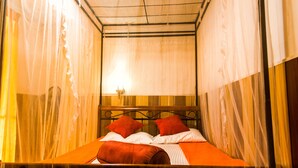 A single bed with a wooden headboard, two red pillows, and a white bedspread. - Ella City Reach Hostel (Ella)