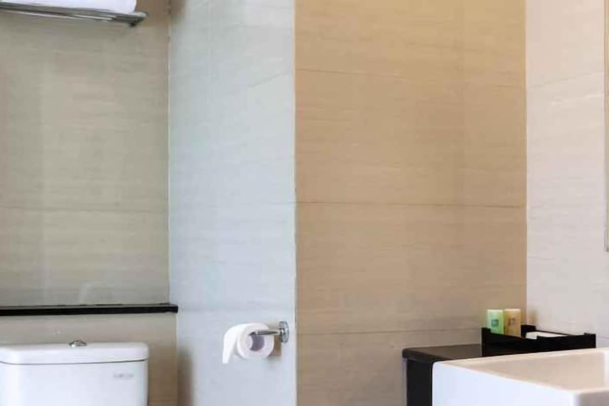 Een badkamer met een toilet, een wastafel en een handdoekhouder.