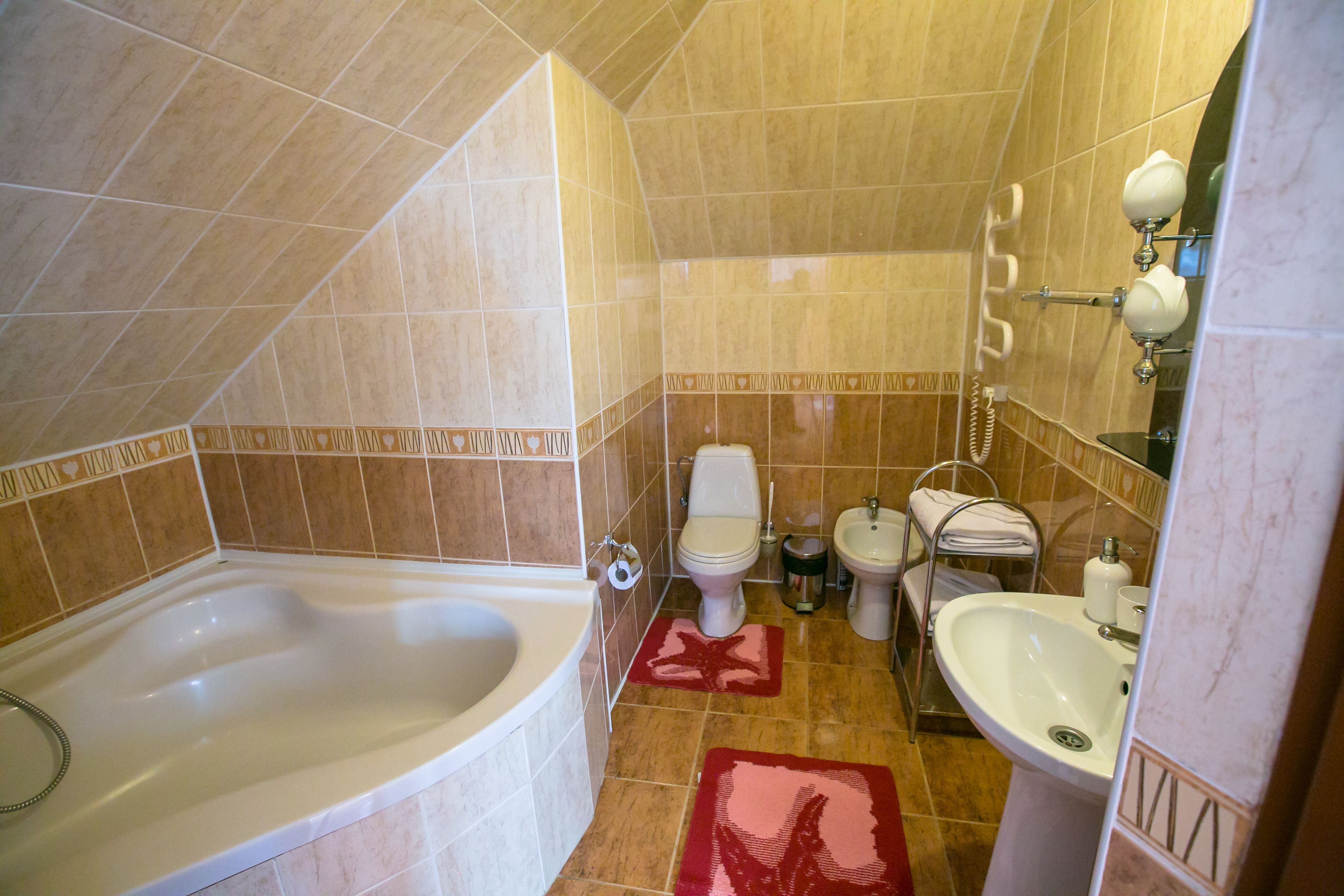 A bathroom with a bathtub, toilet, bidet, and sink.