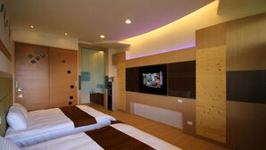 A hotel room with two beds, a TV mounted on the wall, wooden paneling, and a bathroom visible through an open door. - Xu Jia Chayuan B&B (Meishan)