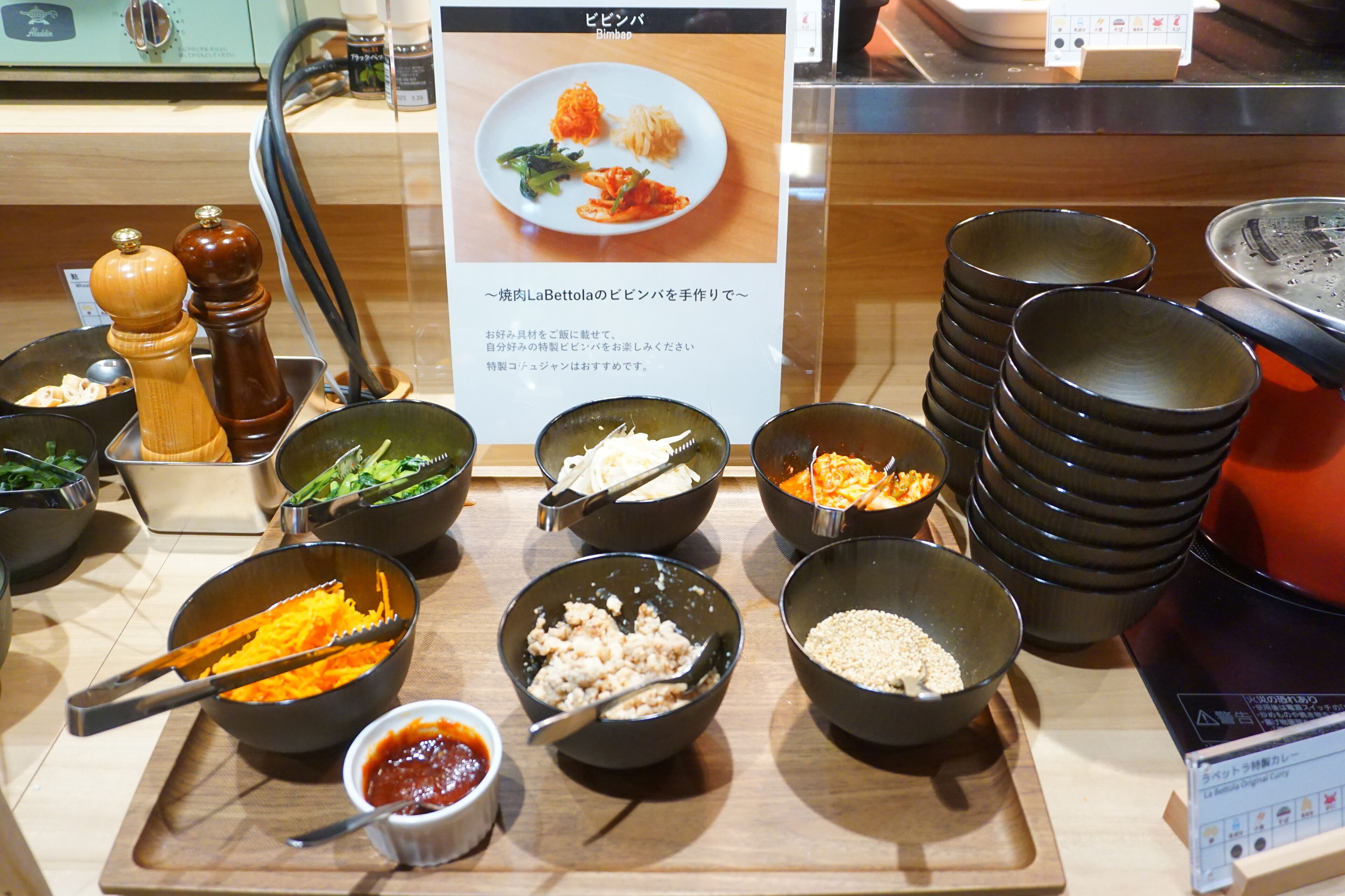 A buffet setup with various dishes and condiments.