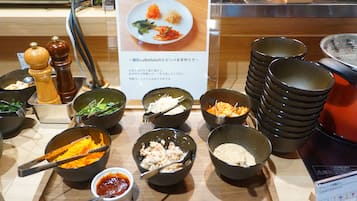 A buffet setup with various dishes and condiments.