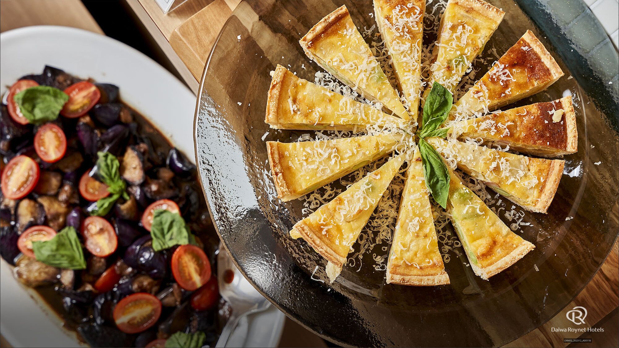 A pie with a lattice crust and a side salad with tomatoes and greens.