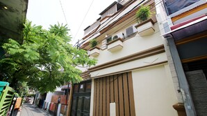 Een smalle straat met gebouwen aan beide kanten, met balkons met planten en airconditioners.