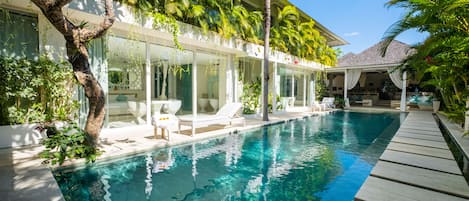 Een buitenzwembad en ligstoelen