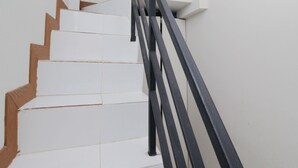 A staircase with white steps and a black metal railing.