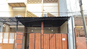 A gated entrance with a metal roof and a wooden gate.