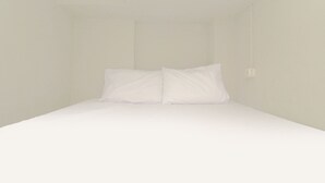 A simple, unadorned room with a bed and a single light fixture.