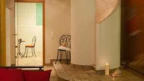 Eine Hotelhalle mit einer gewölbten Wand, einer Sitzecke mit Tisch und Stühlen sowie einer großen Säule.