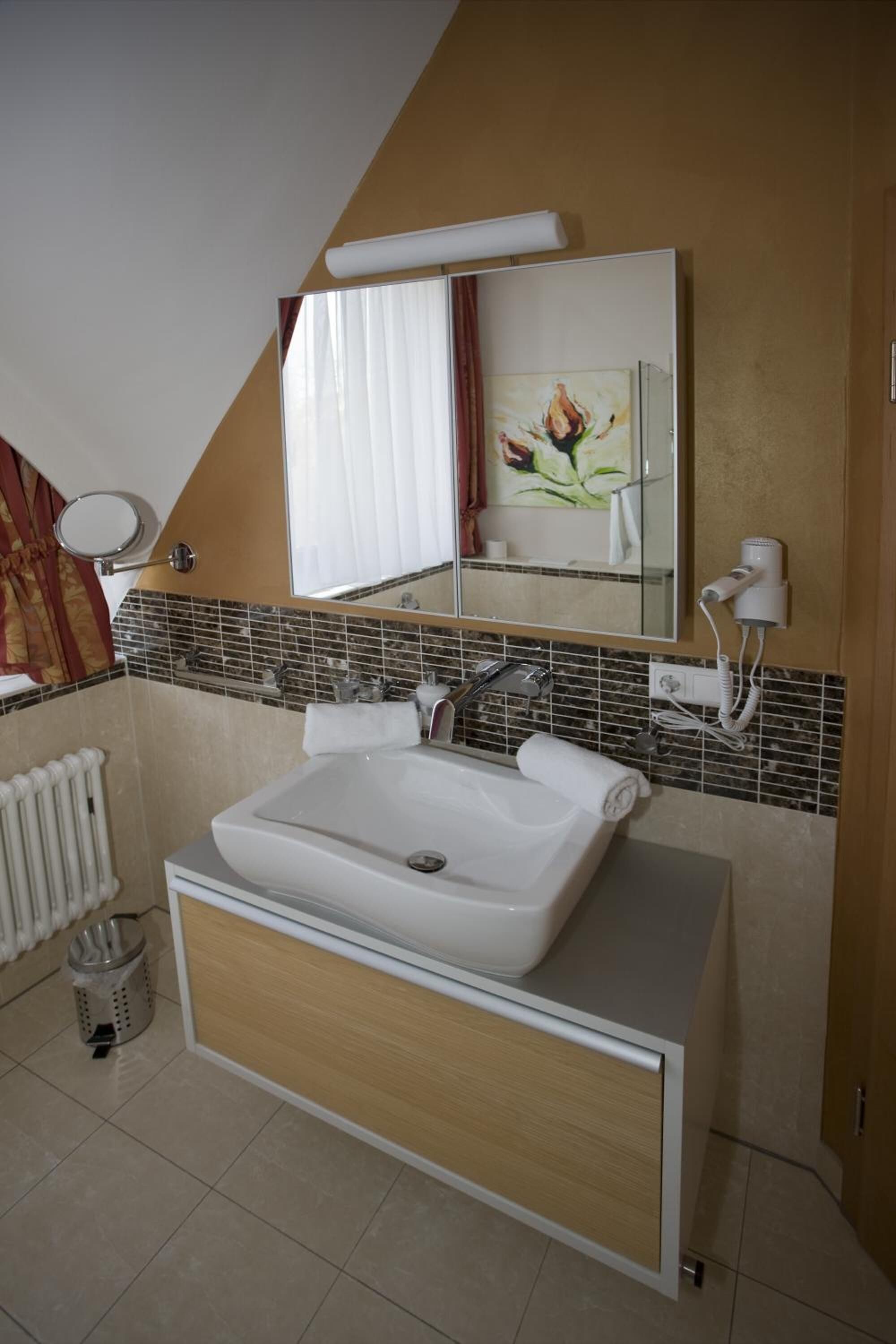 Ein modernes Badezimmer mit einem großen Waschbecken, einem Spiegel und einem Handtuchhalter.