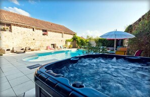 Een bubbelbad met een stenen gebouw op de achtergrond.