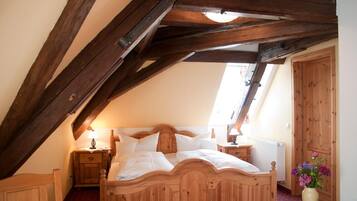 A bedroom with a wooden bed, a nightstand, a lamp, a radiator, and a wooden door.