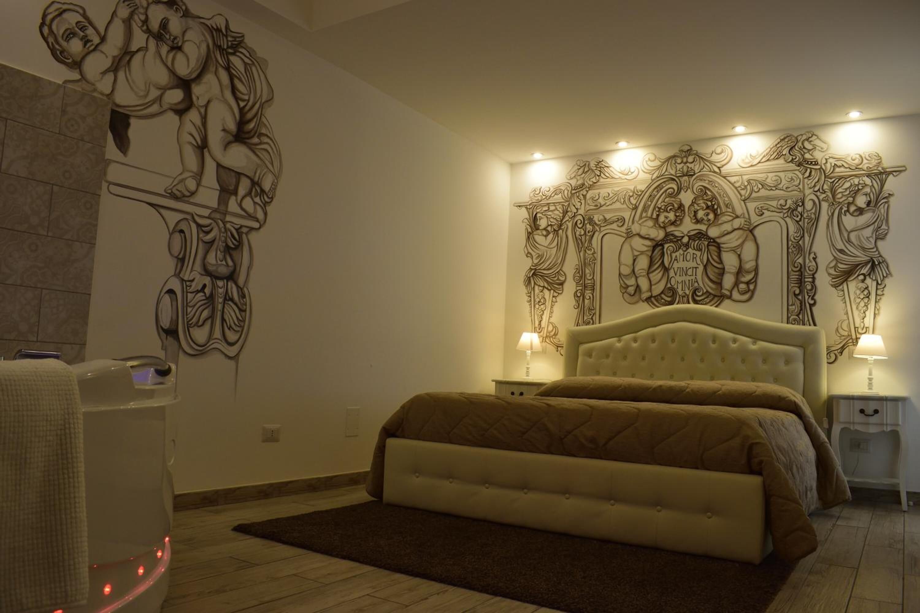 Une chambre avec un grand lit, une œuvre d’art accrochée au mur et un fauteuil de massage.