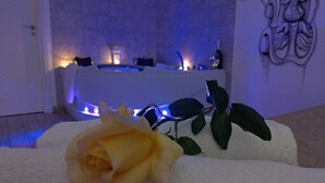 Un baño con una bañera, una toalla blanca y una rosa amarilla.