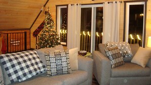 Chalet Deluxe, varias camas, no fumadores, bañera de hidromasaje (Carini Cavern) | Sala de estar | Una televisión de pantalla plana, una chimenea, un reproductor de DVD