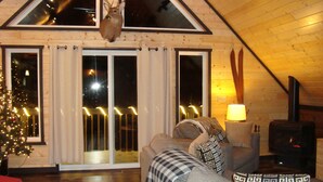 Chalet Deluxe, varias camas, no fumadores, bañera de hidromasaje (Carini Cavern) | Sala de estar | Una televisión de pantalla plana, una chimenea, un reproductor de DVD