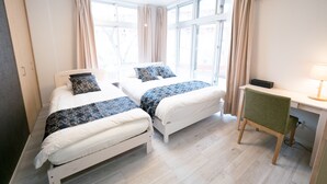 Una habitación de hotel con dos camas, un escritorio y una silla.